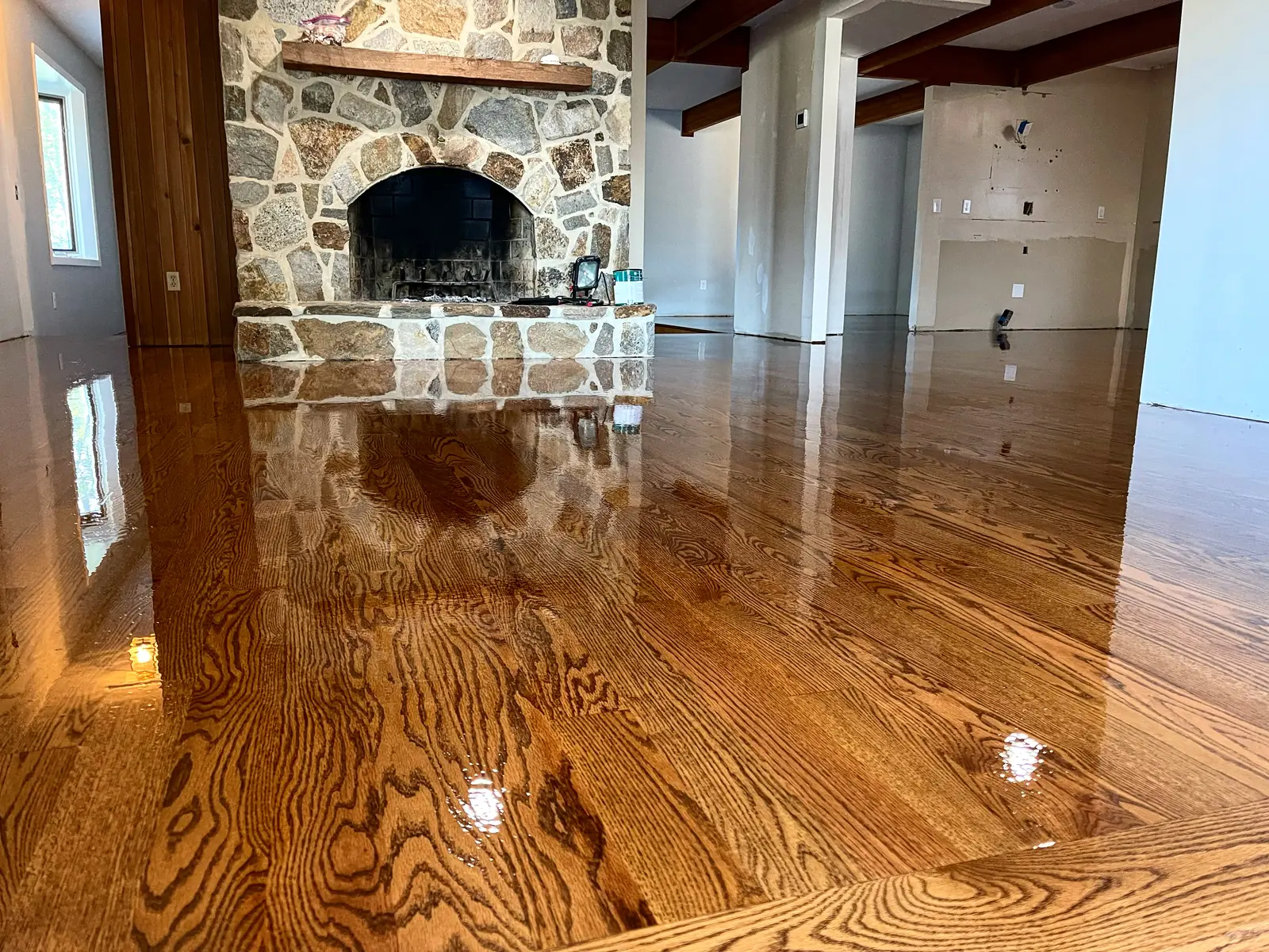 Elegant room with stone fireplace and newly installed hardwood flooring